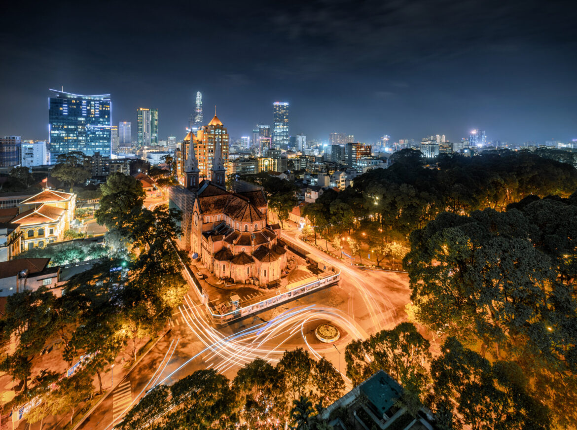 Night view of Notre-Dame Cathedral and downtown Ho Chi Minh City with light trails from traffic